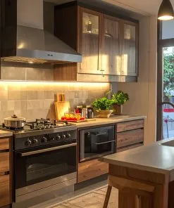 Vietnamese modern kitchen using multiple appliances together, oven, induction stove, cookware set, family cooking together, warm atmosphere, Vietnamese text on containers